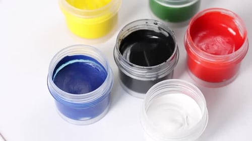 Set de gouache. Ouvrez des pots de peinture. Faites pivoter la table des sujets. Gros plan.