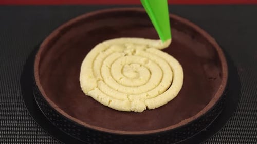 Applying Dough Into Baking Dish To Make Cake on Table
