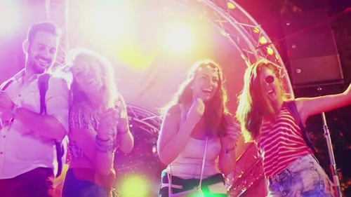 Cheerful Young People Dancing on Stage at Night