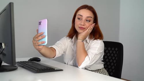 Young Woman Takes Selfie at Desk