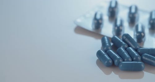 Blue Capsules and Pills on White Surface