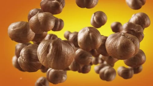 Hazelnuts Floating Against Golden Gradient Background