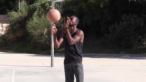Black man spinning basketball on finger