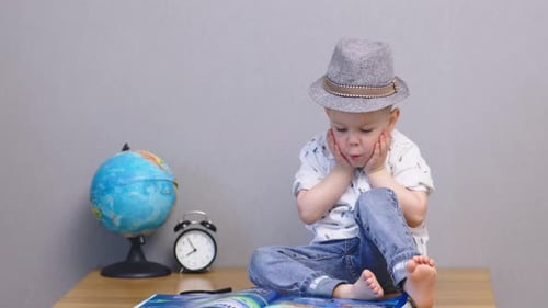 Surprised Wondering Baby Toddler Boy Looking in Book Showing Emotions of Shock