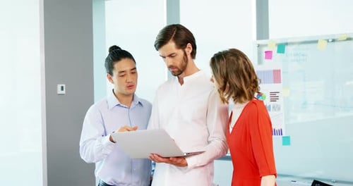 Team Collaboration Around Laptop in Modern Office
