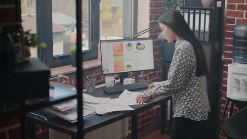 Gros plan d'une femme analysant des documents graphiques sur le bureau