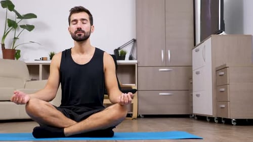 Young Adult Man Meditating at Home
