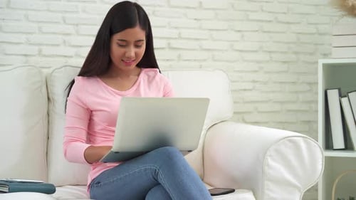 Excited Woman Works on Laptop at Home