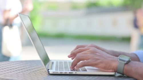 Nahaufnahme eines afrikanischen Mannes, der auf Laptop tippt
