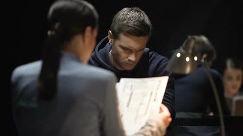 Man Being Interrogated by Police Detective in Dark Room
