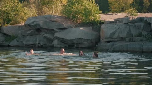 Junge Leute schwimmen im See