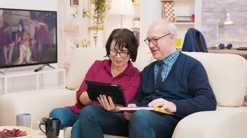 Couple Using Tablet Together on Couch at Home