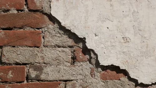Destructed wall white cement plaster 4K 2160p 30fps UltraHD footage - Old brick building facade