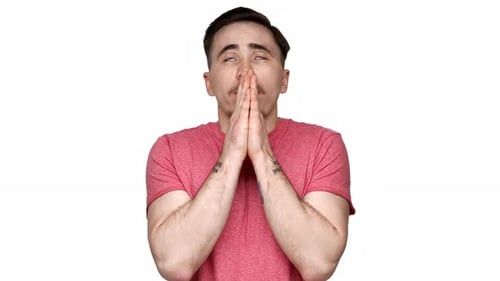 Portrait of Bearded European Man Wearing Casual Tshirt Holding Palms Together and Praying for Luck