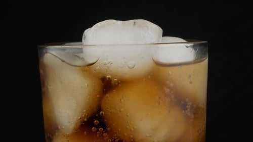 cola with ice cubes close up