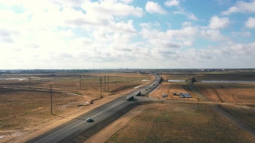 Large trucks with water tanks are driving along the road. Aerial photography from a drone.