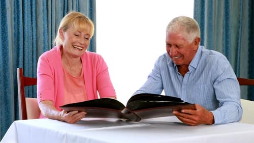 Pareja mayor mirando álbum de fotos