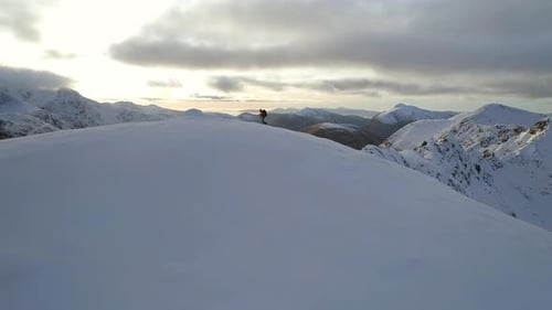 Bergsteiger erreicht den Gipfel eines verschneiten Berges