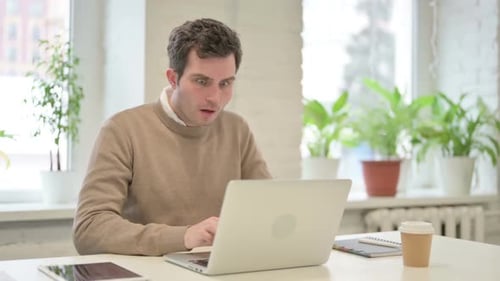 Man Shocked by Computer in Bright Office