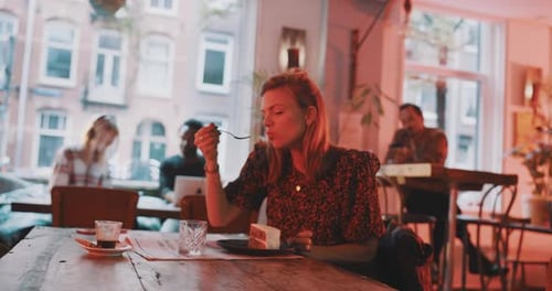 Woman taking a bite of a cake and enjoying it
