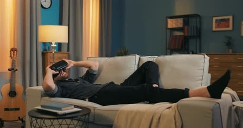 Man Using VR Headset Relaxing on Couch
