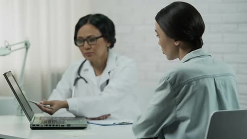 Worried Woman Describing Symptoms to Doctor in Office