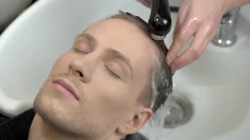 Man Relaxing While Getting Hair Washed at Salon
