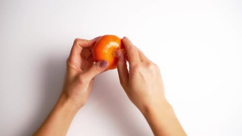 Woman's Hands Peeling Juicy, Fresh Tangerine