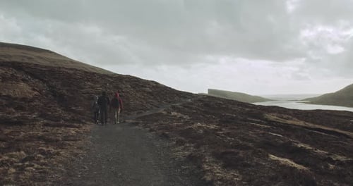 Three people walk together on hillside