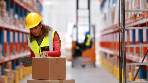 Female warehouse worker using digital tablet