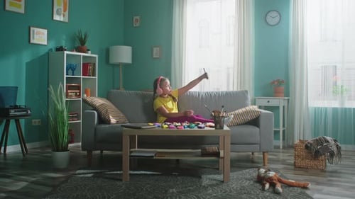 Child on Couch Taking Pictures with Phone