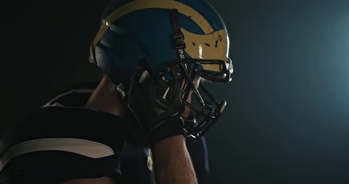 Football Player Putting on Helmet, Close Up