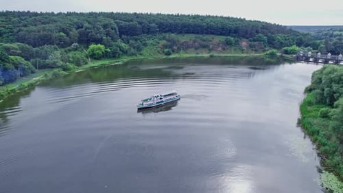 A Small Passenger Ship Sails on the River