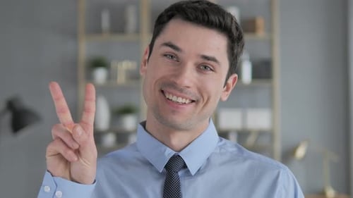 Smiling Man Makes Peace Sign at Camera