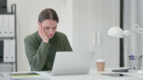 Woman Working on Laptop in Office Looking Frustrated