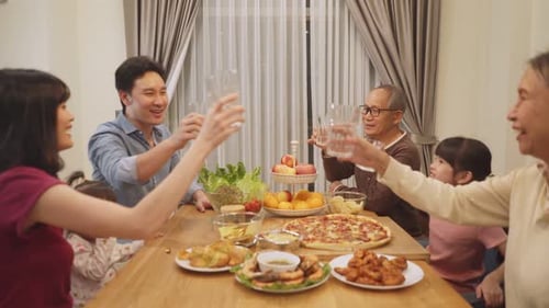 Family Gathers, Toasting at Indoor Dinner Celebration