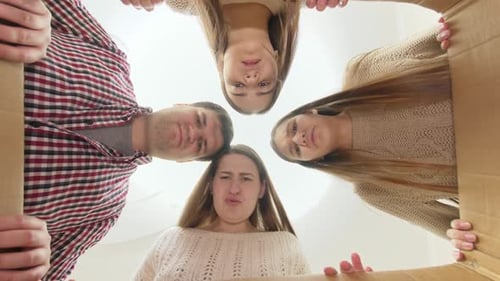 Friends and Family Open Cardboard Box Together