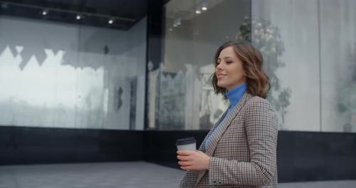 Portrait of the Confident Young Woman That Smiles and Walks Around the City with Coffee in Her Hand