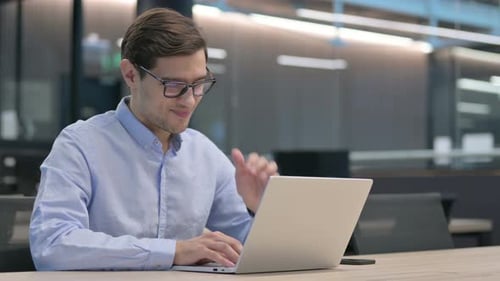 Man Typing on Laptop in Modern Office