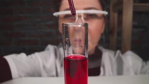 Red Liquid Being Added to Test Tube in Lab