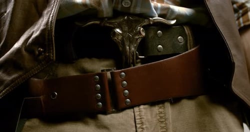 Gros plan de la ceinture d'un cow-boy et de l'incroyable taureau sur la boucle de ceinture, 4k