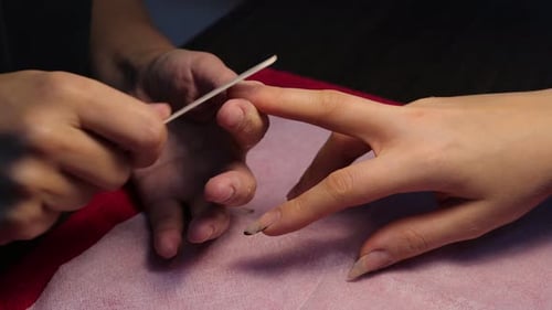 Manicurist Filing Nails at Nail Salon