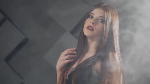 Fashionable Woman Posing in Smoky Studio Setting