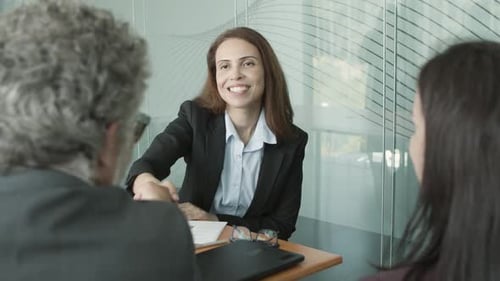 Businesswoman Shakes Hands with Colleagues in Office Meeting