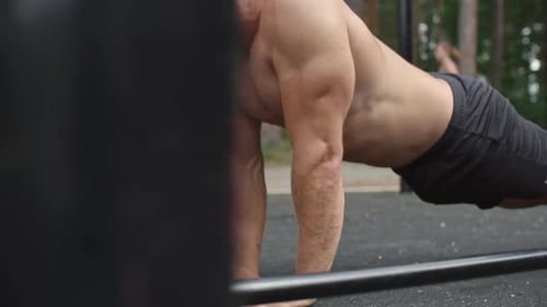 Muscular Man Doing Push-Ups in Outdoor Gym