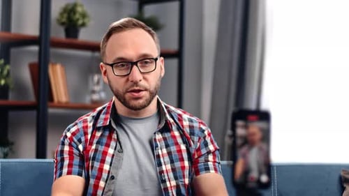Man with Glasses Talking on Camera Indoors