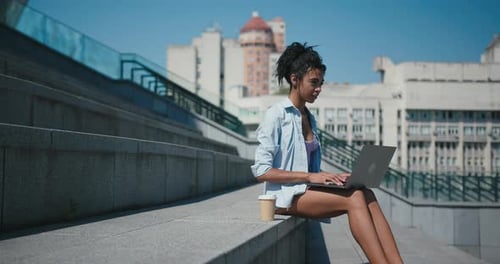 Pretty Mixed Race Lady Works on Laptop Sitting on Steps