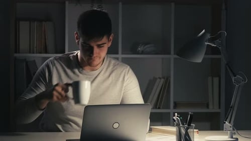 Young Adult Working at Laptop at Night
