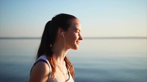 Young Pretty Woman Listen to the Music Using a Headphones