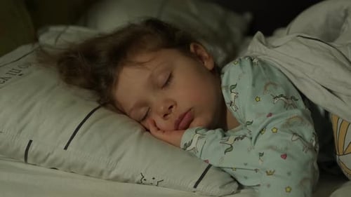 Young Girl Sleeping Peacefully in Bed at Night